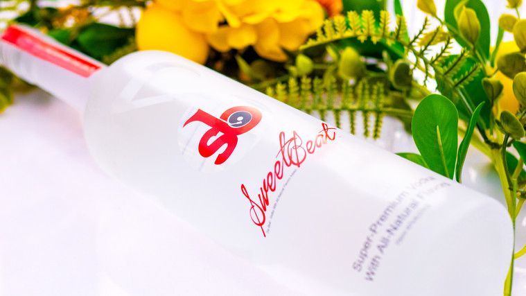 SweetBeat Vodka bottle in an elegant floral setting