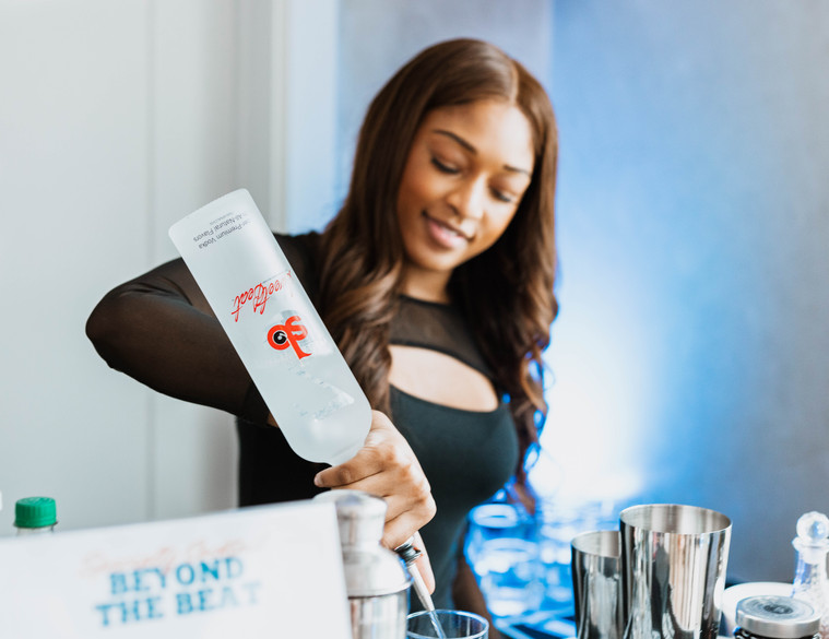 Smiling bartender mixing drinks behind the bar