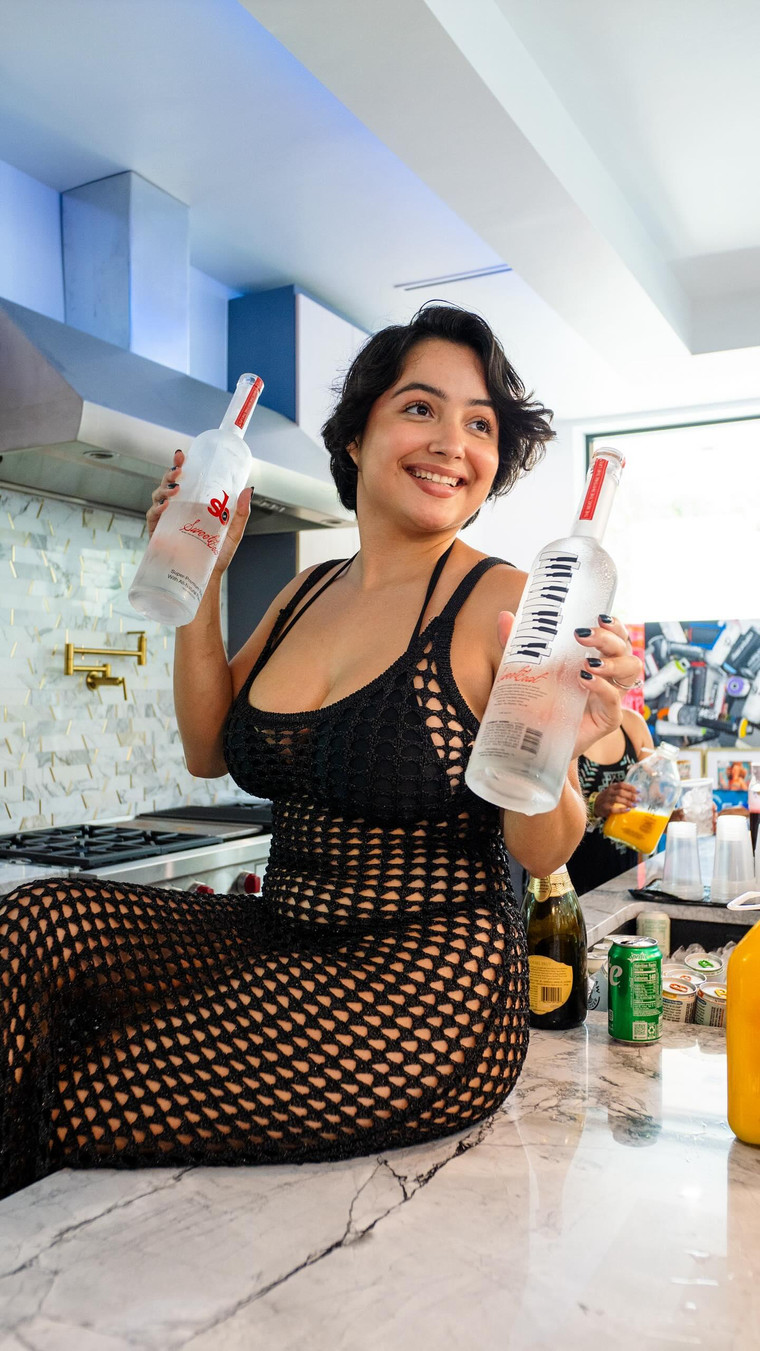 Woman enjoying SweetBeat Vodka in a social setting